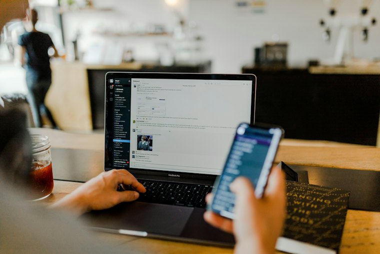 Personne apprenant à coder sur un ordinateur portable et un téléphone